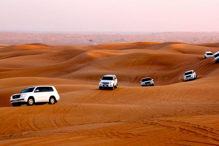 Experience the excitement of a desert adventure as 4x4 vehicles traverse golden dunes leading you to spectacular views and a taste of authentic Bedouin culture under twinkling stars.